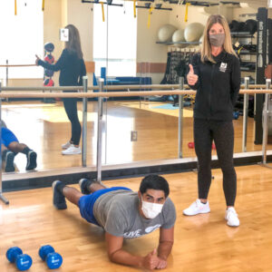 A trainer assisting a gym member.