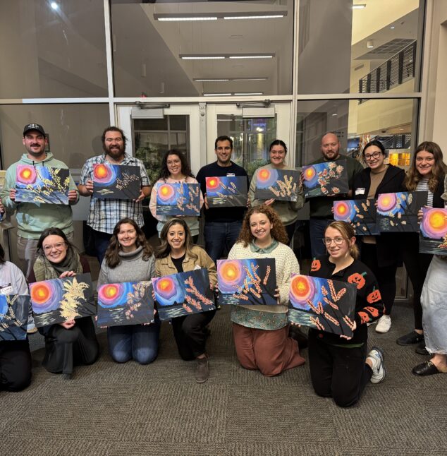 People posing with their art pieces.