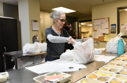 Woman packaging meals for Meals on Wheels