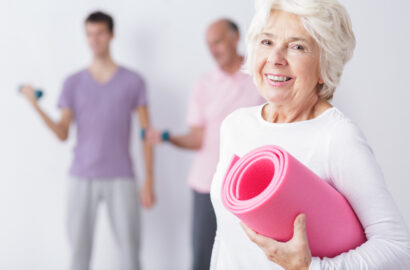 Photo of happy elderly woman at gym after training.
