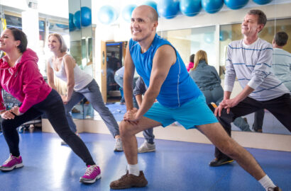 group of smiling mature people involved in sports gym.