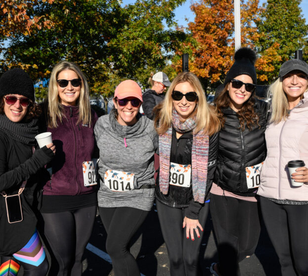 A group of woman volunteering at a 5K running event.