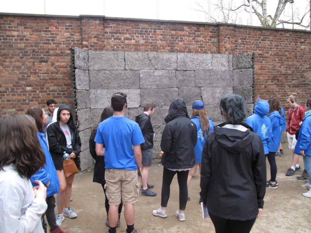 Visitors stand outside a wall