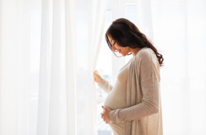 Pregnant woman looking out window
