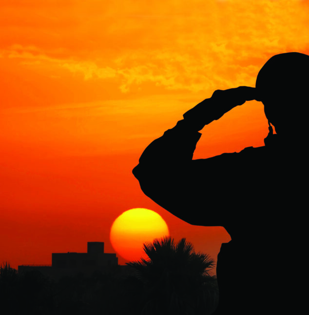Silhouette Of A Solider Saluting Against the Sunrise in a town on the Mediterranean coast.
