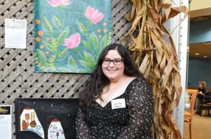 Under One Roof participant next to art piece
