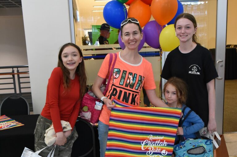 Family smiling at Rainbow Challah Bake