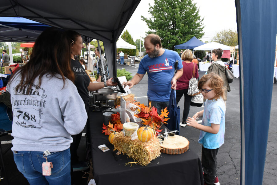 People standing at booth at Fall Market.