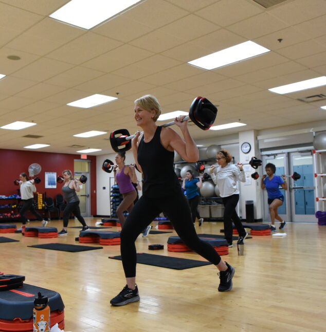 Body Pump Class. Instructor holding barbell.