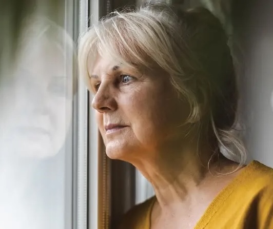 Woman staring out the window, sadly
