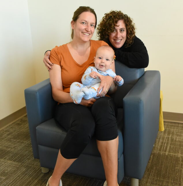Mom posing with a friend and her baby.