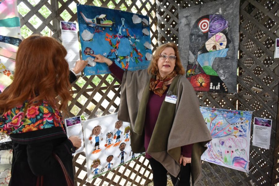 Person looking at art work under the sukkah.