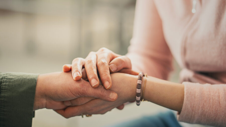 Cropped image of two people holding hands