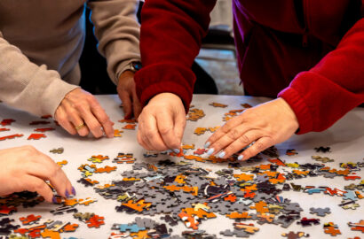 Cropped view of hands working on a jigsaw puzzle