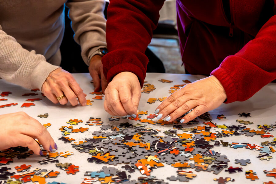 Cropped view of hands working on a jigsaw puzzle