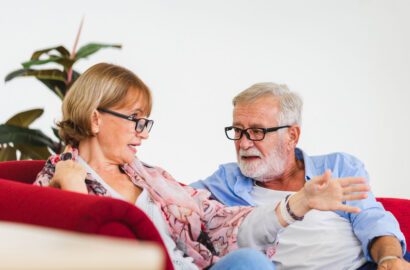 Two seniors talking on a couch
