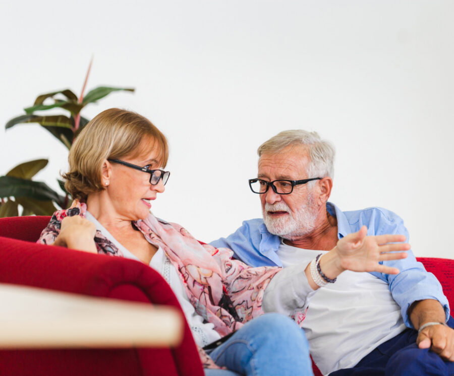 Two seniors talking on a couch