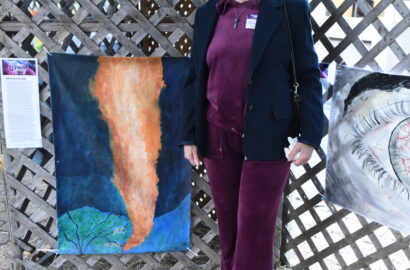 Woman standing next to artwork in a sukkah