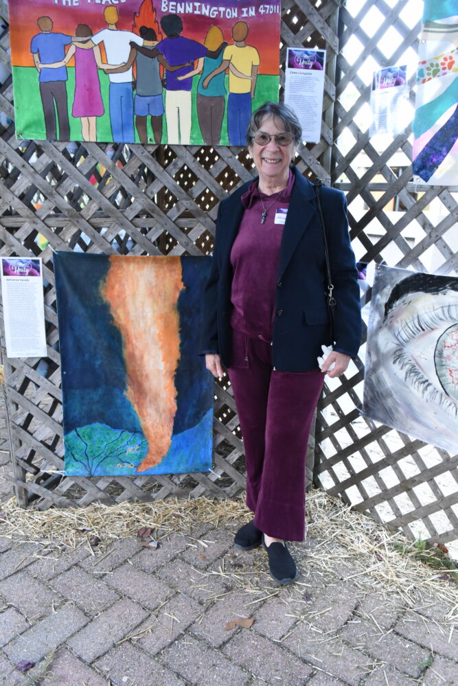 Woman standing next to artwork in a sukkah